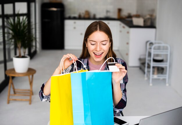 Femme excitée regardant à l'intérieur des sacs de vacances