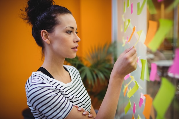 Femme exécutif lecture des notes autocollantes