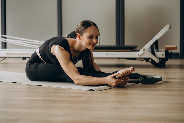 Femme exerçant le pilates sur le réformateur