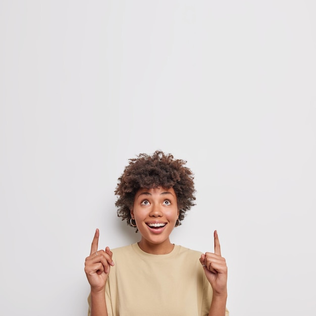 femme avec une expression heureuse a un regard incroyable vêtue de vêtements décontractés isolés sur blanc. Wow quelle belle offre pour vous.