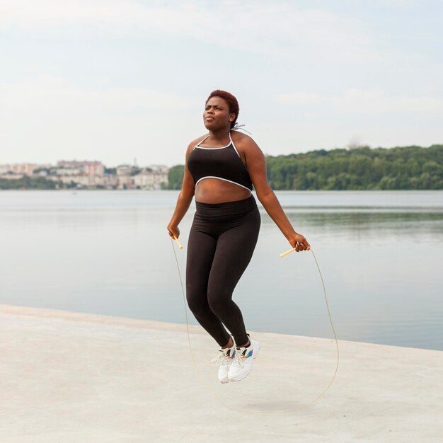 Femme à l'extérieur corde à sauter