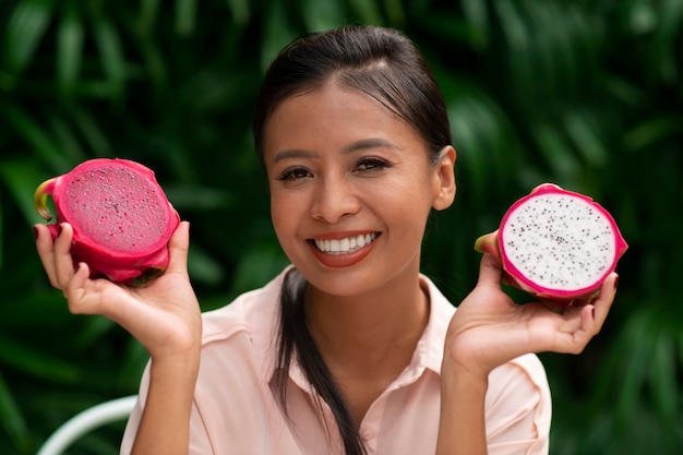 Femme à l'extérieur avec des fruits du dragon