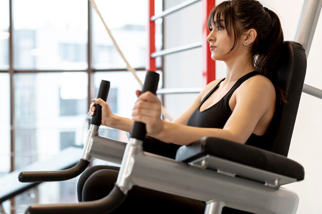 Femme faible angle au gymnase exercice