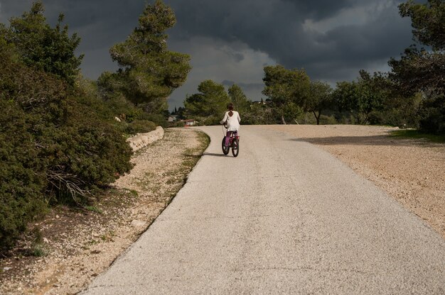 Femme, faire du vélo sur la route pendant la journée