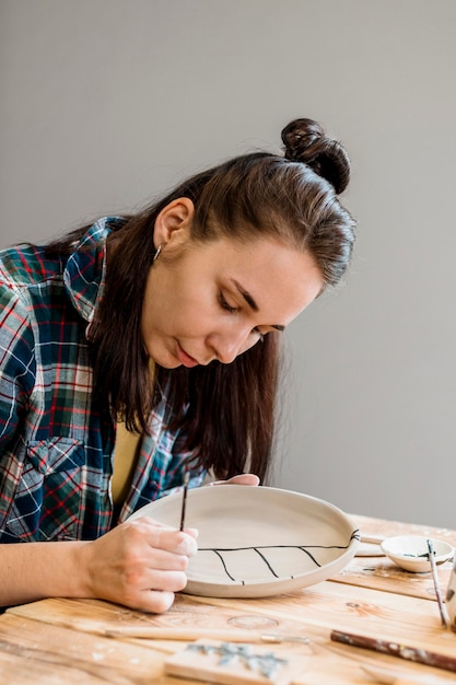 Photo gratuite femme faisant un chef-d'œuvre de poterie