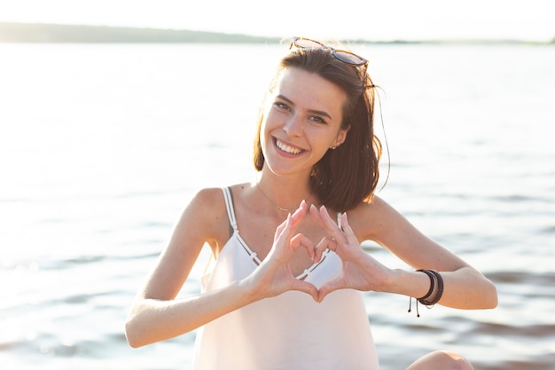 Femme faisant un coeur avec ses mains