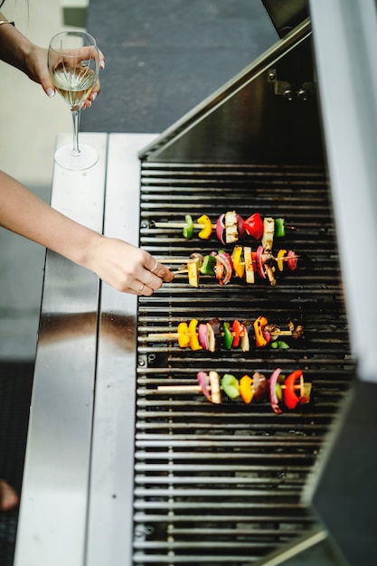 Femme faisant la cuisine végétalienne sur un barbecue au charbon