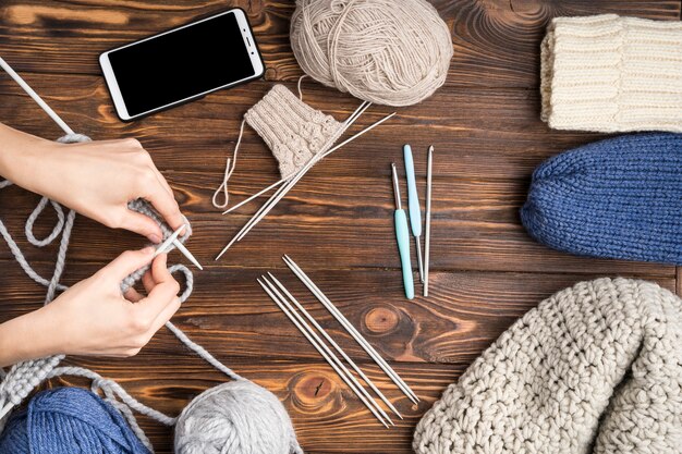 Femme faisant du crochet sur fond en bois