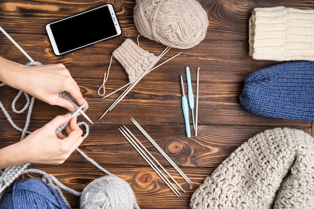 Femme faisant du crochet sur fond en bois