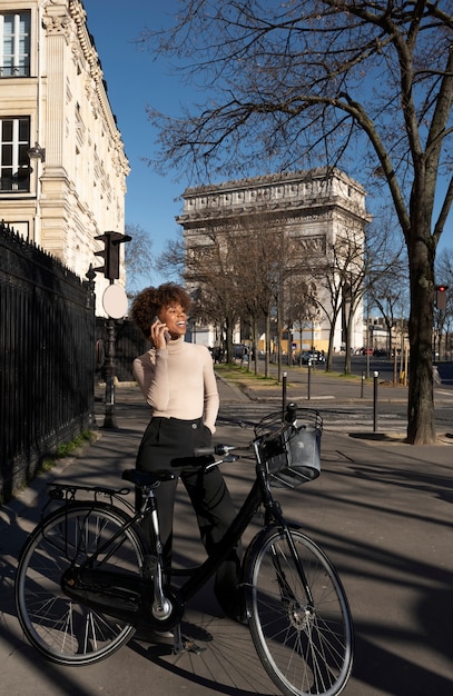 Photo gratuite femme faisant du vélo et parlant sur le smartphone dans la ville de france