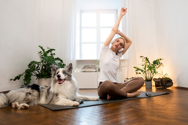 Photo gratuite femme faisant du yoga accompagnée de son animal de compagnie