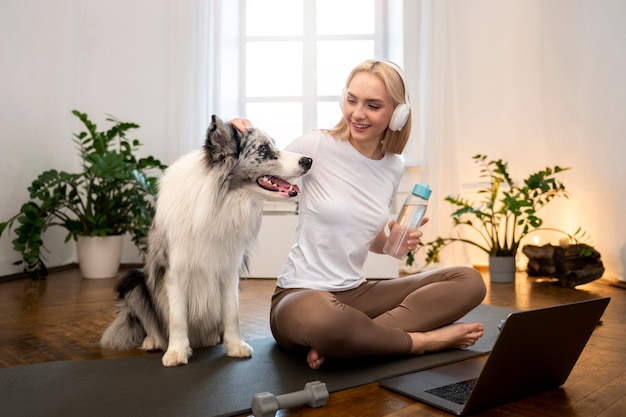 Photo gratuite femme faisant du yoga accompagnée de son animal de compagnie