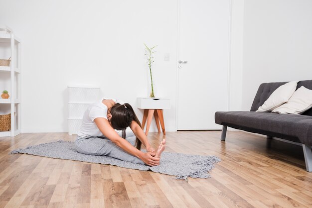 Femme faisant du yoga à la maison