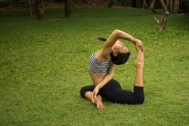 Femme faisant du yoga sur la pelouse