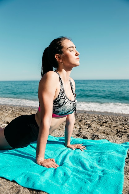 Femme faisant du yoga à la plage