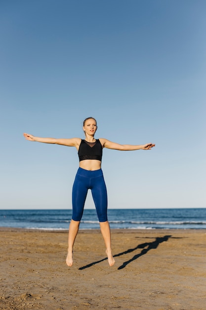 Femme faisant de la gymnastique à la plage