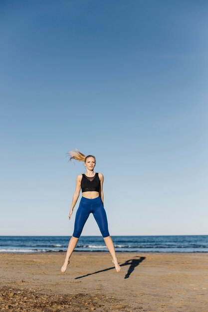 Femme faisant de la gymnastique à la plage