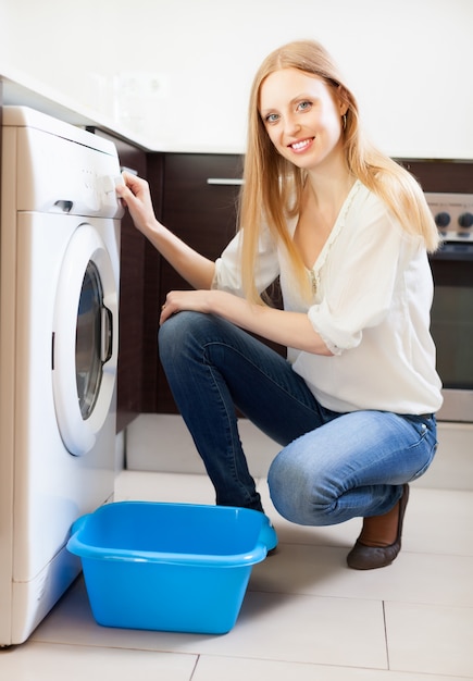 femme faisant la lessive avec machine à laver