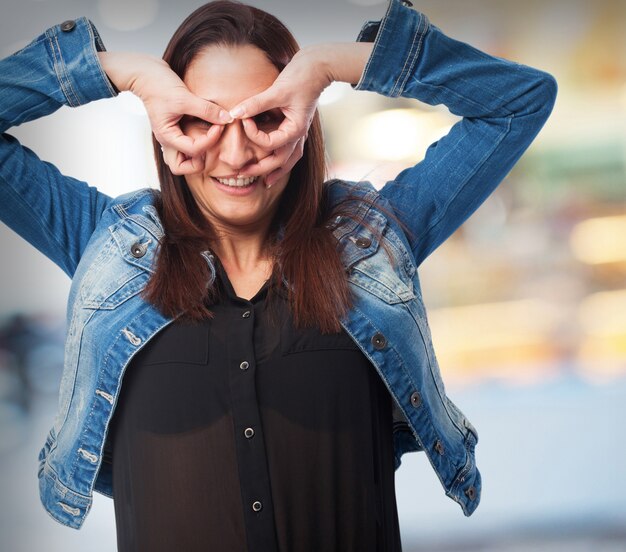 Femme faisant des lunettes avec ses mains