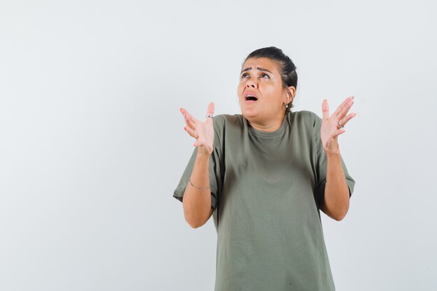 femme faisant semblant de garder quelque chose en t-shirt et à la peur