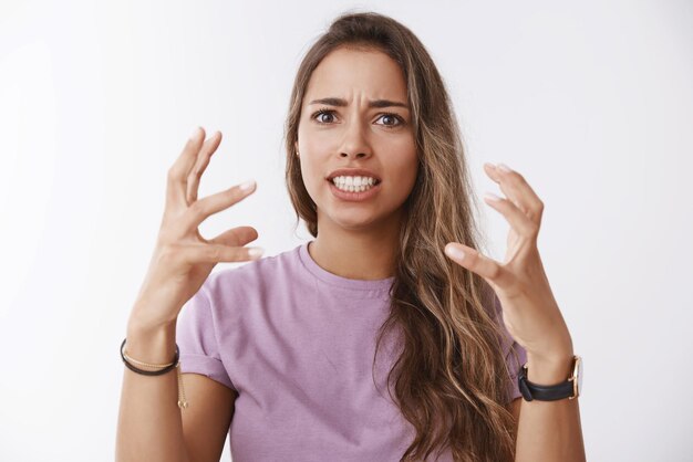 Une femme fatiguée et énervée a levé les mains, agacée, furieuse