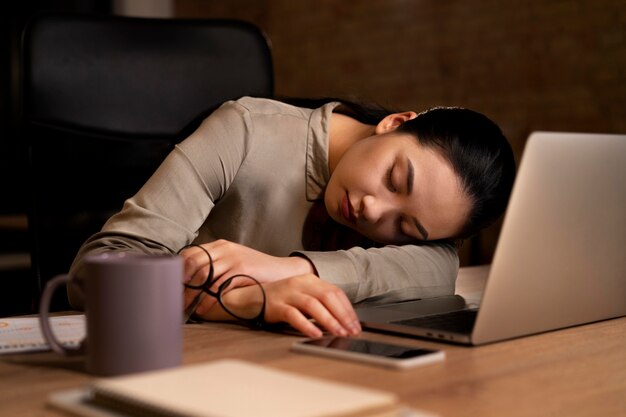 Femme fatiguée travaillant tard au bureau