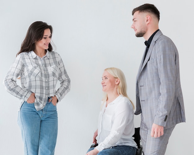 Femme en fauteuil roulant conversant avec ses collègues