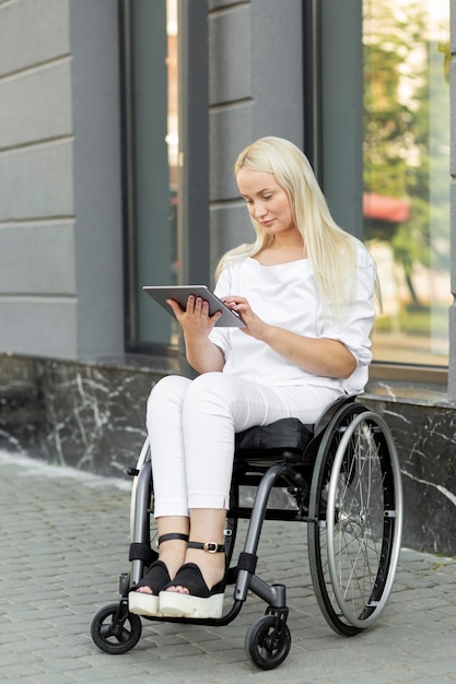 Femme en fauteuil roulant avec tablette