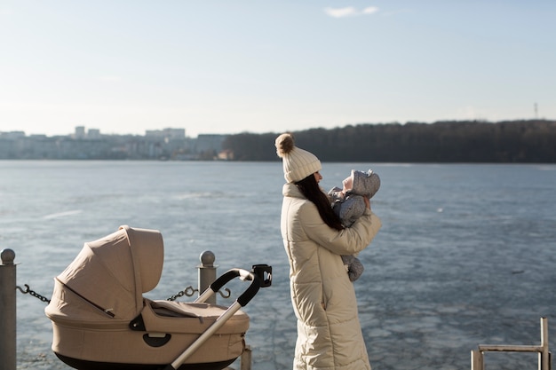 Femme femme avec bébé sur le front de mer d&#39;hiver