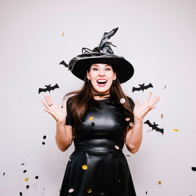 Femme festif émotionnelle qui lance des confettis pour Halloween