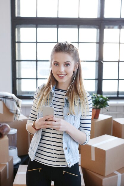 Une femme a fini avec des colis et écoute de la musique au téléphone