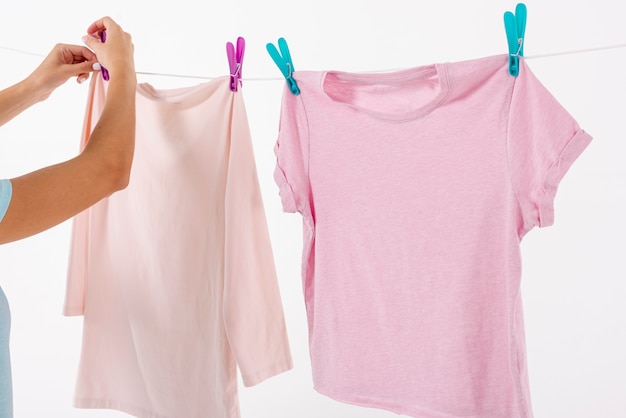 Photo gratuite femme fixant des t-shirts sur une corde à linge avec des pinces à linge