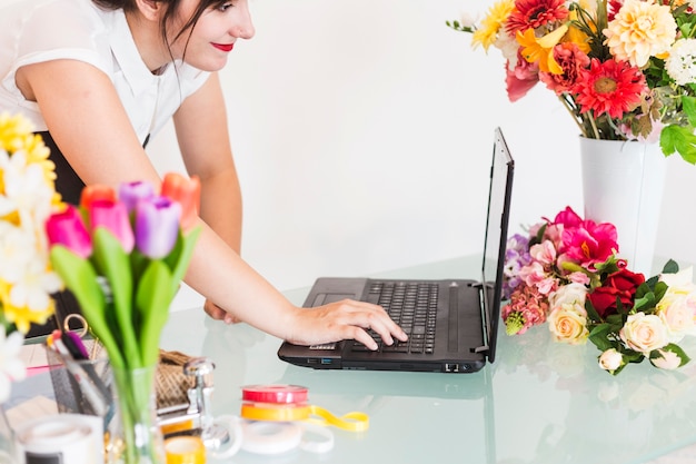 Femme fleuriste utilisant un ordinateur portable sur le bureau