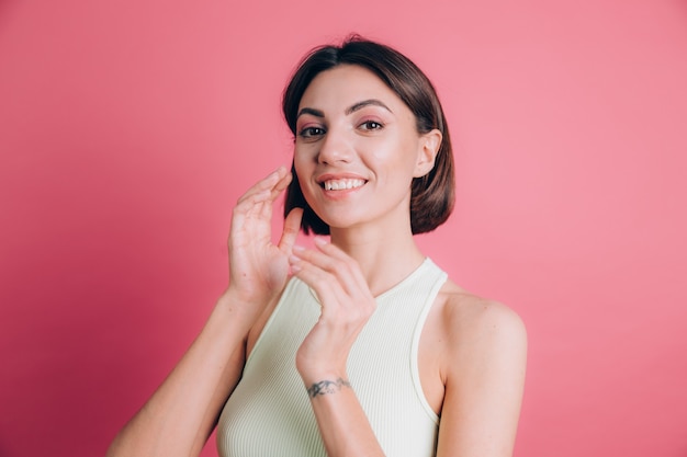 Femme sur fond rose visage heureux souriant en regardant la caméra. Personne positive.