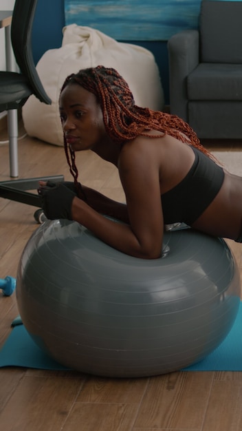 Photo gratuite femme en forme athlétique travaillant les muscles abdominaux tout en étant assise sur un ballon suisse de yoga