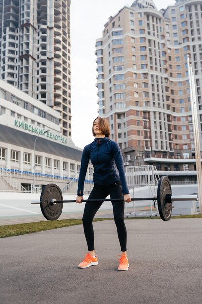 Femme forte exerçant avec le concept de remise en forme de sports d'haltères