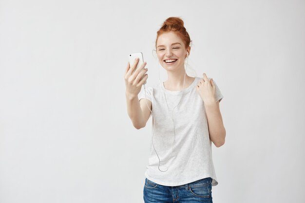 Femme foxy joyeuse souriant parlant au téléphone dans les écouteurs.