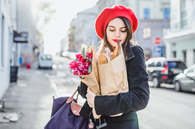 Femme française avec des baguettes dans la rue en béret