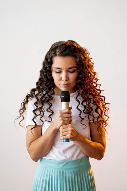 Femme frisée chantant dans un microphone