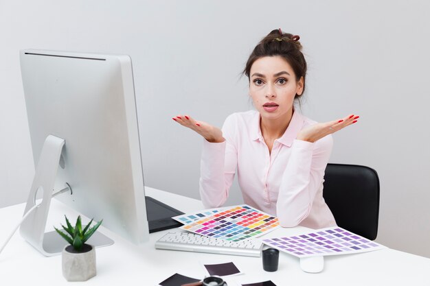 Femme frustrée au bureau entourée de palettes de couleurs