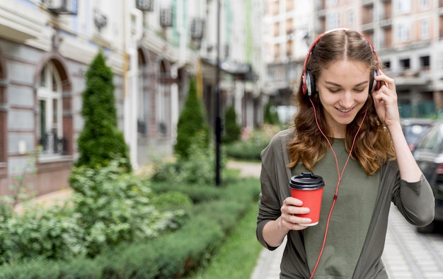 Photo gratuite femme grand angle avec café et casque