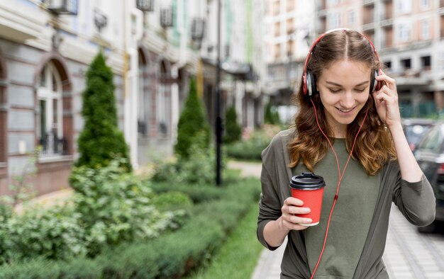 Femme grand angle avec café et casque