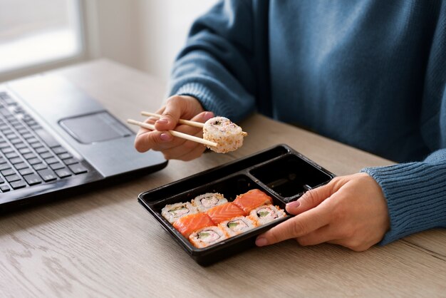 Femme grand angle avec de délicieux sushis à la maison