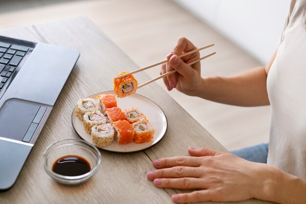 Femme grand angle avec de délicieux sushis à la maison