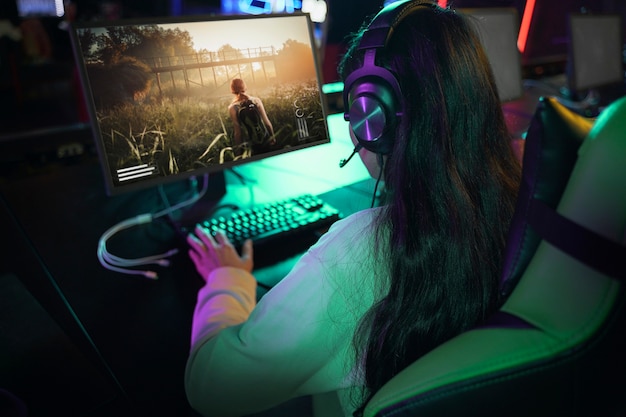 Femme grand angle jouant au jeu vidéo sur ordinateur