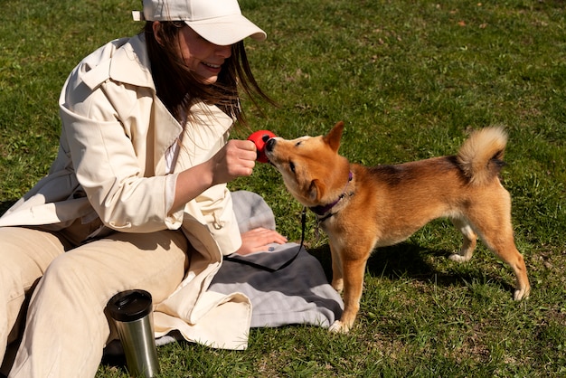 Photo gratuite femme grand angle jouant avec un chien mignon