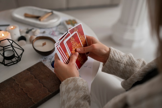 Femme grand angle lisant le tarot à la maison