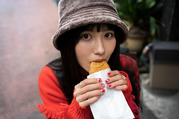 Femme grand angle mangeant de la pâtisserie