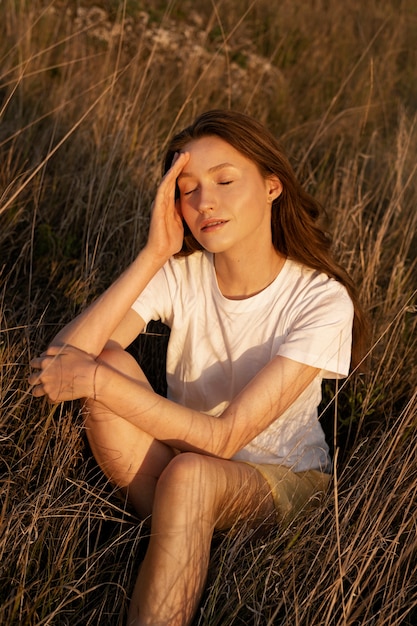 Femme grand angle posant au coucher du soleil