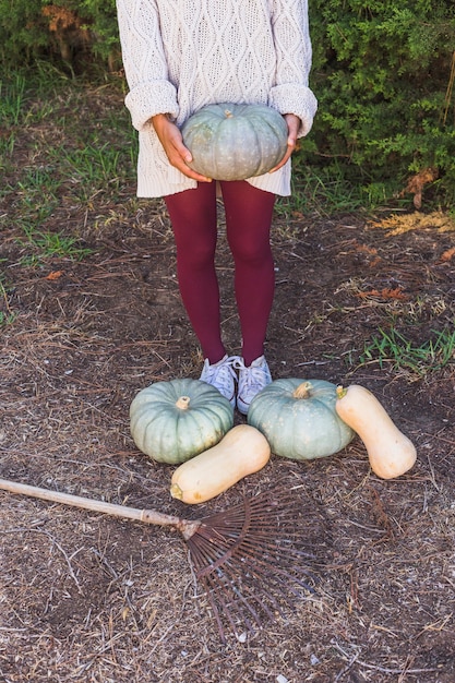 Femme avec gros légumes et râteau